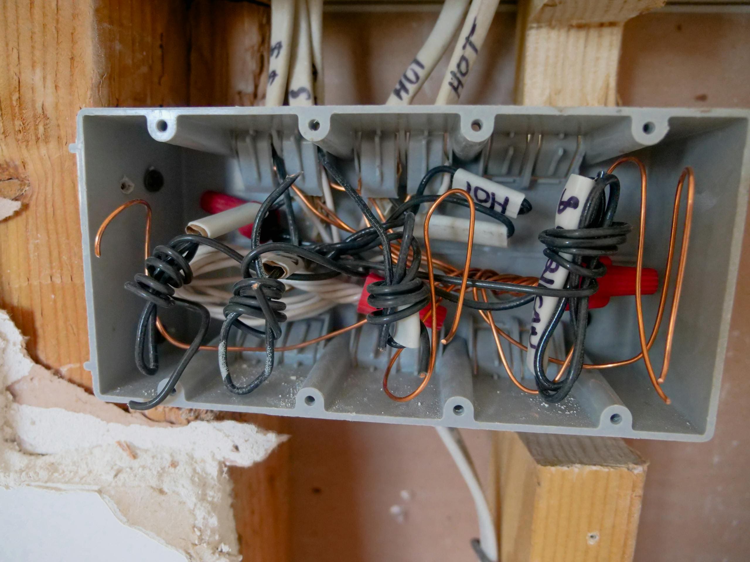 Detailed view of an open electrical switchboard with tangled wires and cables.